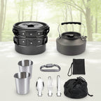 Collection of camping cookware and utensils including pots, kettle, cups, and cutlery