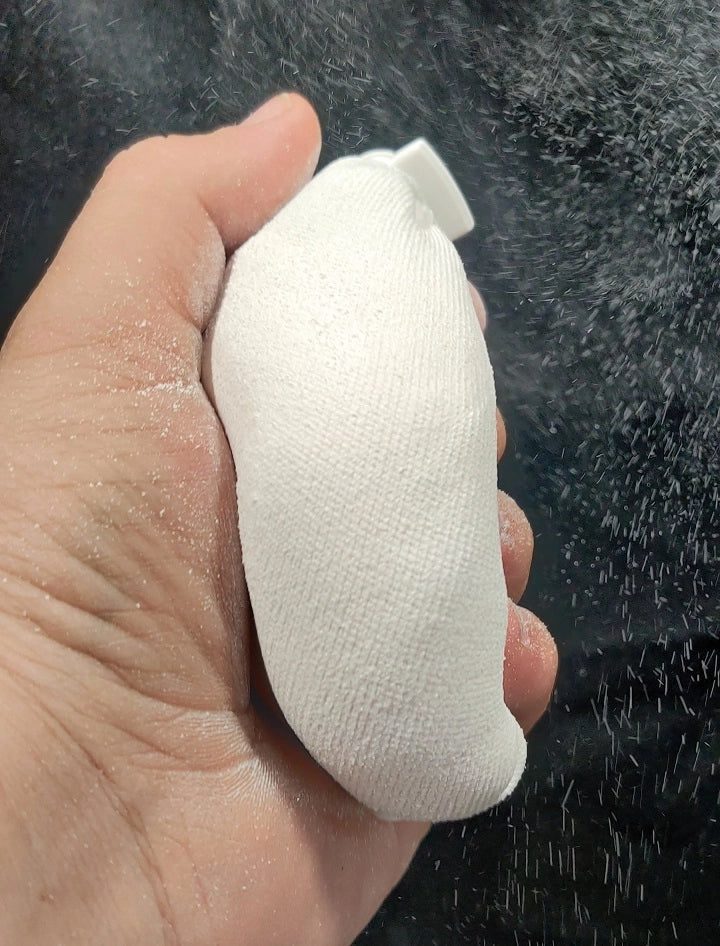 Hand holding a white chalk ball