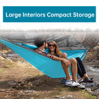 Two people sitting in a blue hammock with a mesh screen, surrounded by nature.