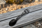 Black eating utensil multi-tool with images showing its uses.