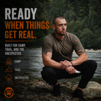 Man squatting by a river with outdoor gear, surrounded by nature.