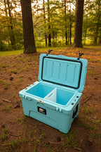 Blue cooler box with a black lid against a brick wall.