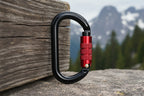 Black and red carabiner on a white background - offered by the best hiking and climbing gear store in New York, The Adirondack Tool Company