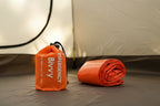 Two orange emergency bivvy sacks from The Adirondack Tool Co. with drawstrings on a white background