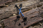 Two blue and black hiking poles on a snowy surface - offered by the premier hiking and climbing gear store in the Northeastern United States, The Adirondack Tool Co.