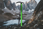 Green ice axe with black strap on a white background