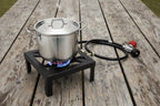 Black portable stove with hose on a white background. Offered by The Adirondack Tool Co.
