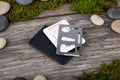 Stainless steel multitool card with various labels on a white background