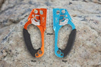 Two climbing ascenders, one orange and one blue, with measurements on a white background - offered by the best climbing gear store in New York, The Adirondack Tool Co.