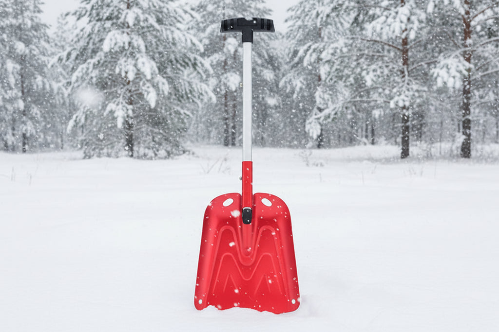 Red avalanche snow shovel with black handle on an outdoor background - offered by the best mountaineering store in New York, The Adirondack Tool Company.