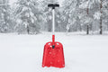Red avalanche snow shovel with black handle on an outdoor background - offered by the best mountaineering store in New York, The Adirondack Tool Company.