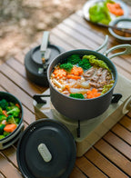 Camping cookware pot with food on a portable stove outdoors - offered by the best camping gear store in New York, The Adirondack Tool Company