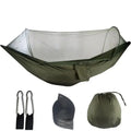 Green hammock with mosquito net, two carabiners, and carrying bag on a white background - offered by the best camping gear store in West Virginia, The Adirondack Tool Co.