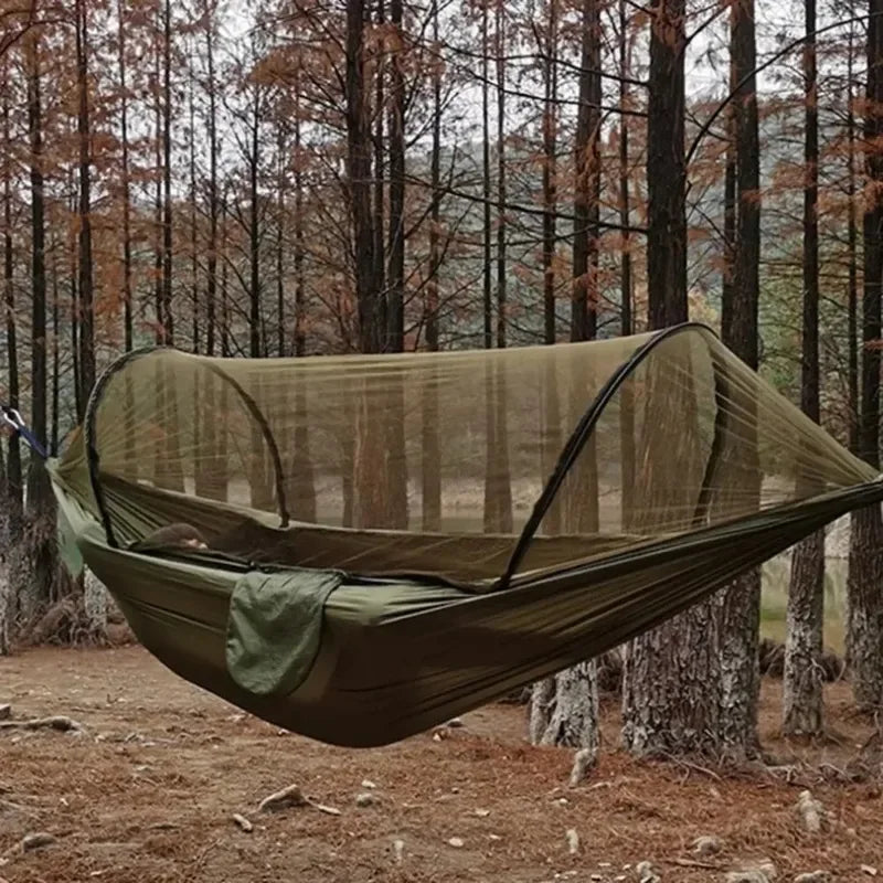 Green mosquito net hammock in a forest setting - offered by the best camping gear store in West Virginia, The Adirondack Tool Co.