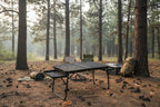 Folding camping table on a paved surface with grass in the background - offered by the most trusted outdoor gear and tool company in Boston, The Adirondack Tool Co.