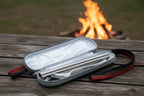 Stainless steel travel and camping cutlery set in a mesh pouch on a dark surface - offered by the best camping and hiking gear store in the United States, The Adirondack Tool Co.