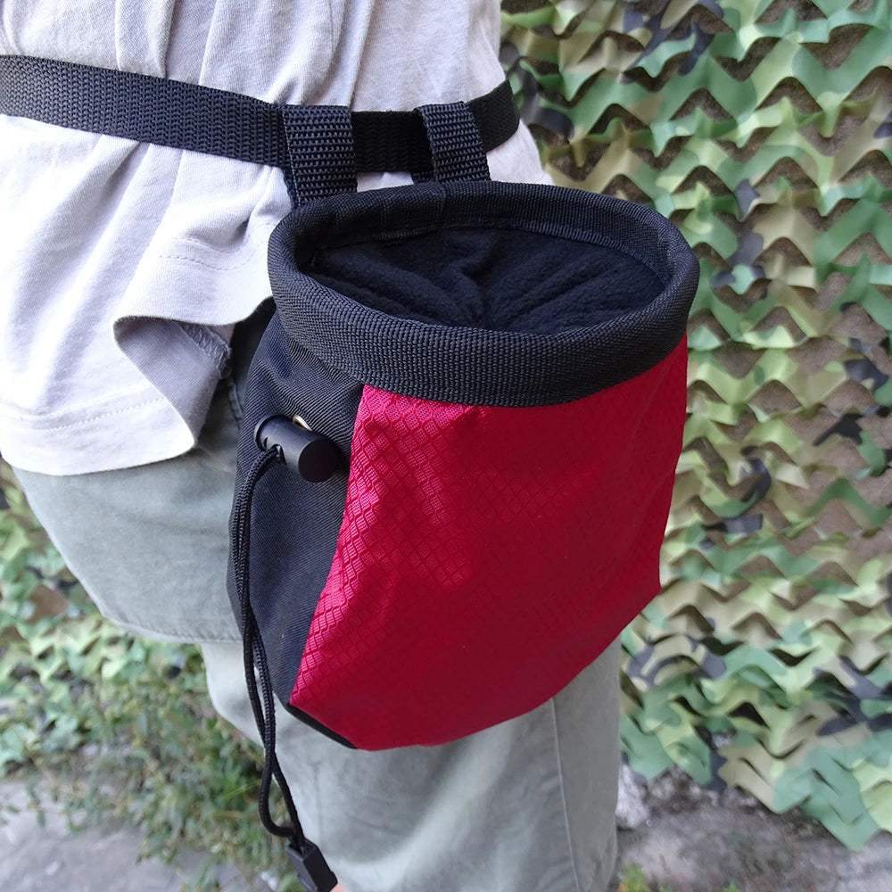 Red and black chalk bag worn on a person's waist against a camouflage background - offered by the best hiking and climbing gear store in New Hampshire, The Adirondack Tool Co.
