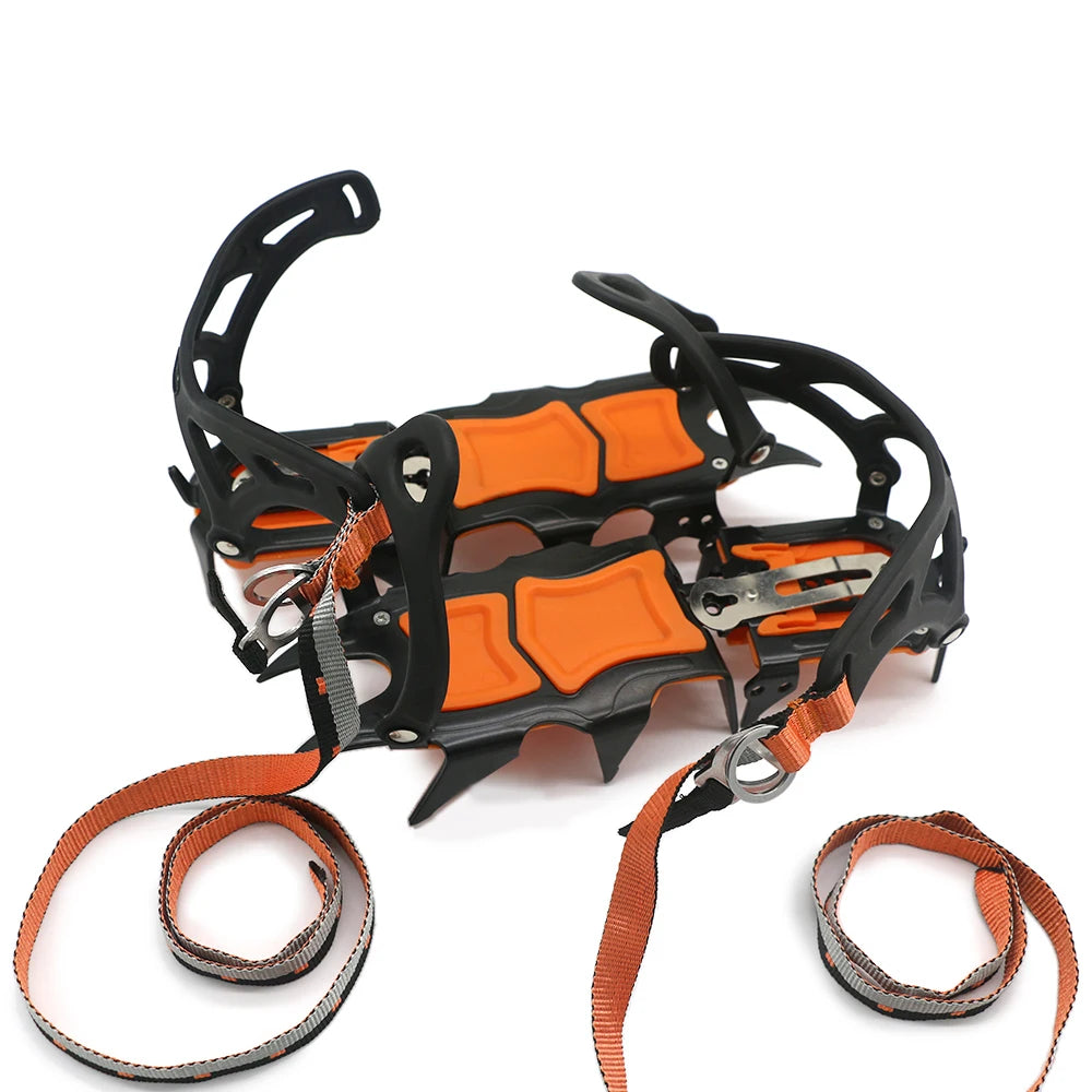 Pair of orange and black crampons with straps on a white background - offered by the best hiking and camping gear store in Massachusetts, The Adirondack Tool Co.