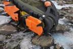 Close-up of an orange and black crampon on a boot with white background - offered by the best hiking and camping gear store in Massachusetts, The Adirondack Tool Co.