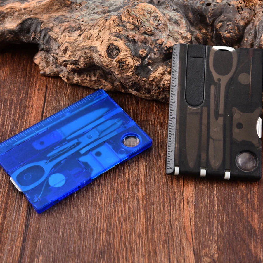 Blue and black multi-tool cards on a wooden surface with a rock in the background - offered by the best outdoor gear store in New York, the Adirondack Tool Company