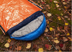 A blue sleeping bag inserted into the orange emergency bivvy bag from The Adirondack Tool Co.