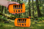 Orange emergency tent package held by a hand on a white background