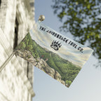 Flag with scenic design and 'The Adirondack Tool Co.' branding on a building