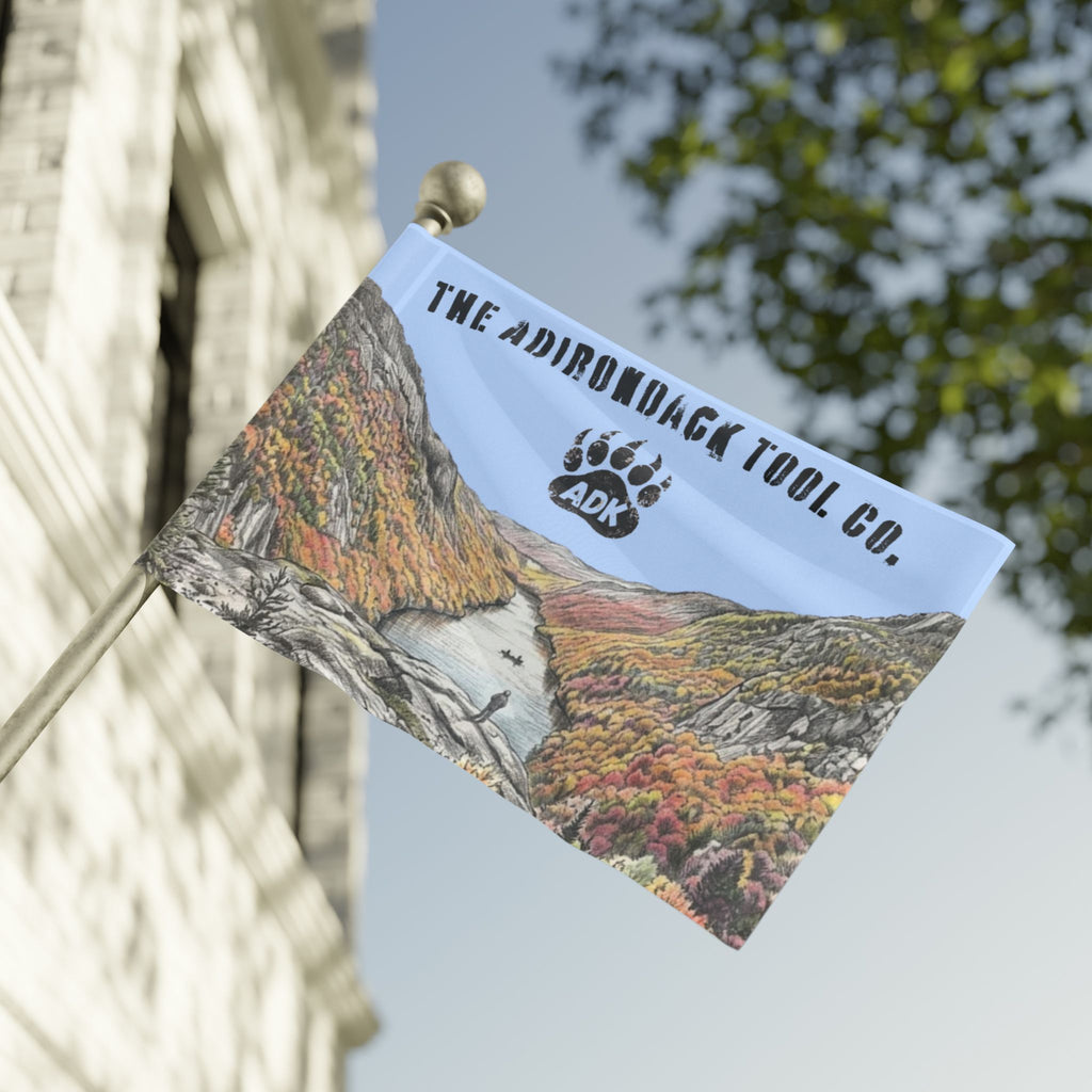 Flag with mountain design and 'The Adirondack Tool Co.' logo on a building