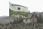 Flag with a scenic design of a cabin and mountains, featuring the Adirondack Tool Co. logo.
