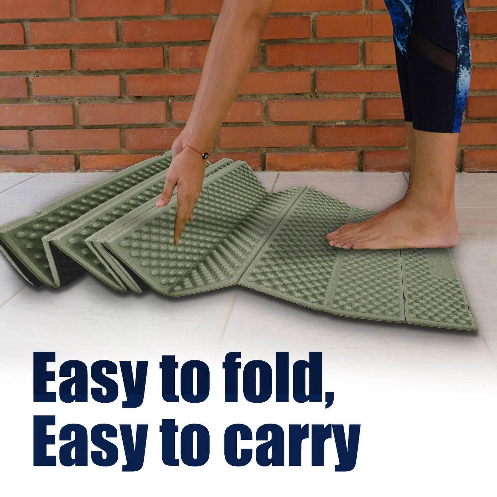 Person folding a green foam mat with text 'Easy to fold, Easy to carry' against a brick wall background - offered by The Adirondack Tool Co.