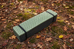 Foldable green foam sleeping/sitting mat on a white background