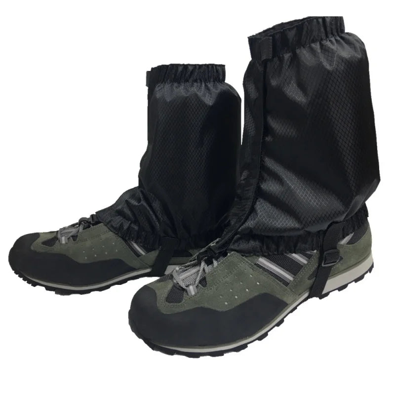 Black hiking gaiters on green hiking boots with a white background offered by the Northeast's best camping and hiking gear provider, The Adirondack Tool Co.