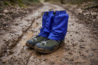 Blue gaiters over black hiking boots on a white background offered by the Northeast's best camping and hiking gear provider, The Adirondack Tool Co.