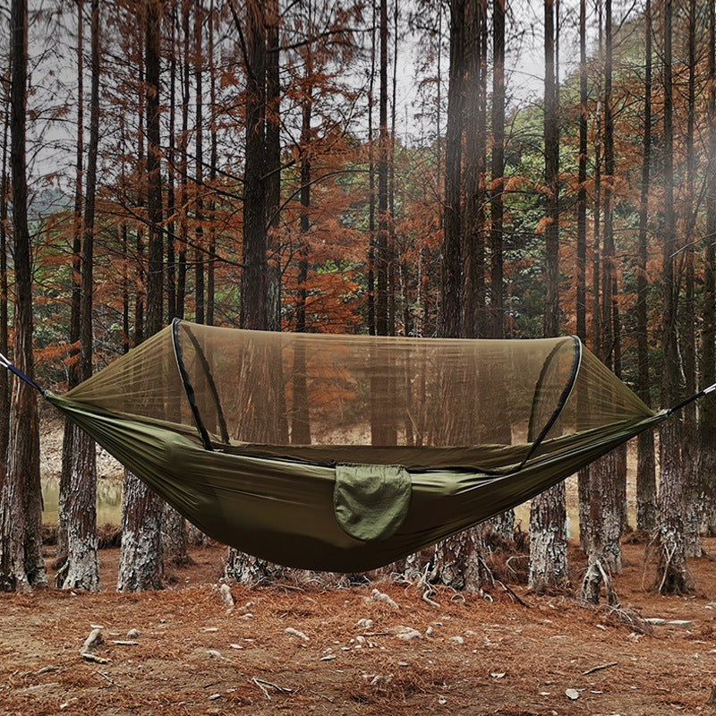 Green hammock with mosquito net in a forest setting