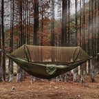 Green hammock with mosquito net in a forest setting