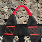 Close-up of a black safety harness with red padding and stitching