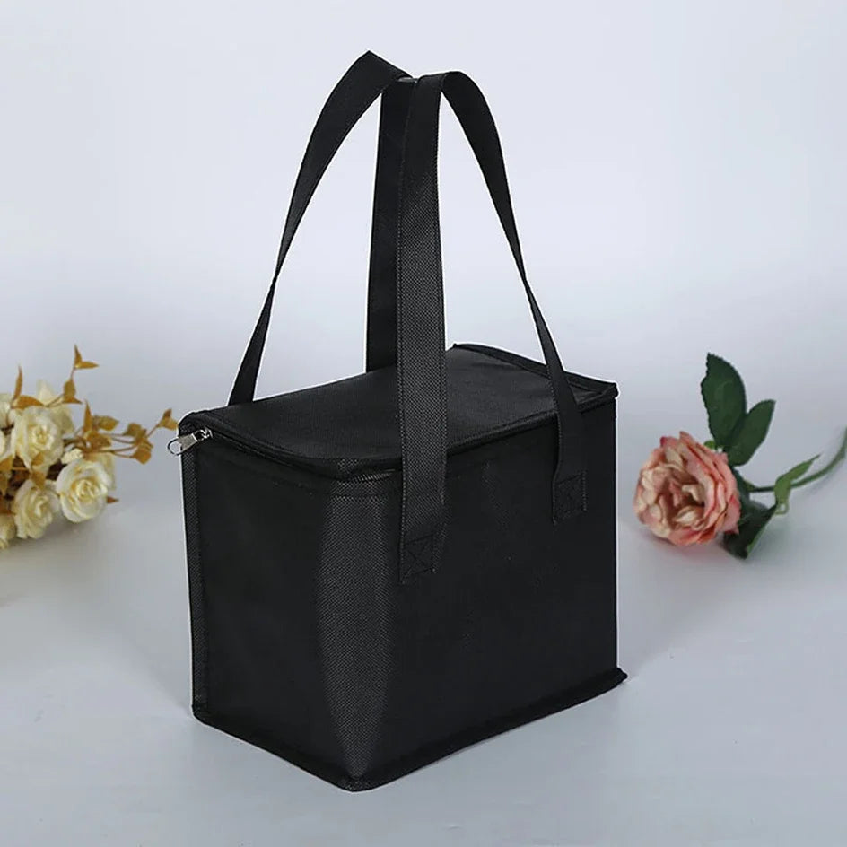 Black insulated cooler bag on a white background with flowers - offered by the most reliable camping, hiking, and climbing gear store in the New England region, The Adirondack Tool Co.