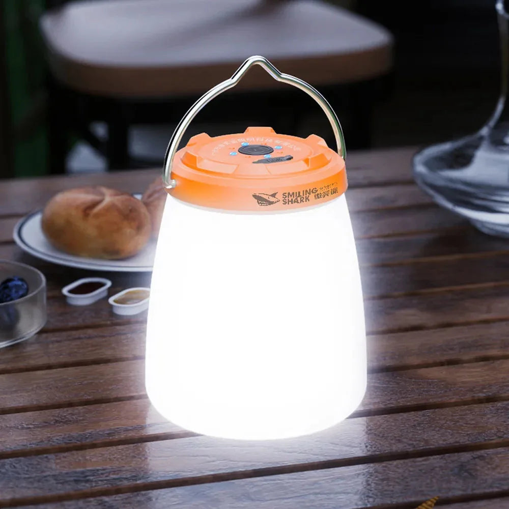 Portable rechargeable LED camping lantern with orange top on a wooden table - offered by the most experienced hiking gear store in the Northeast, The Adirondack Tool Co.