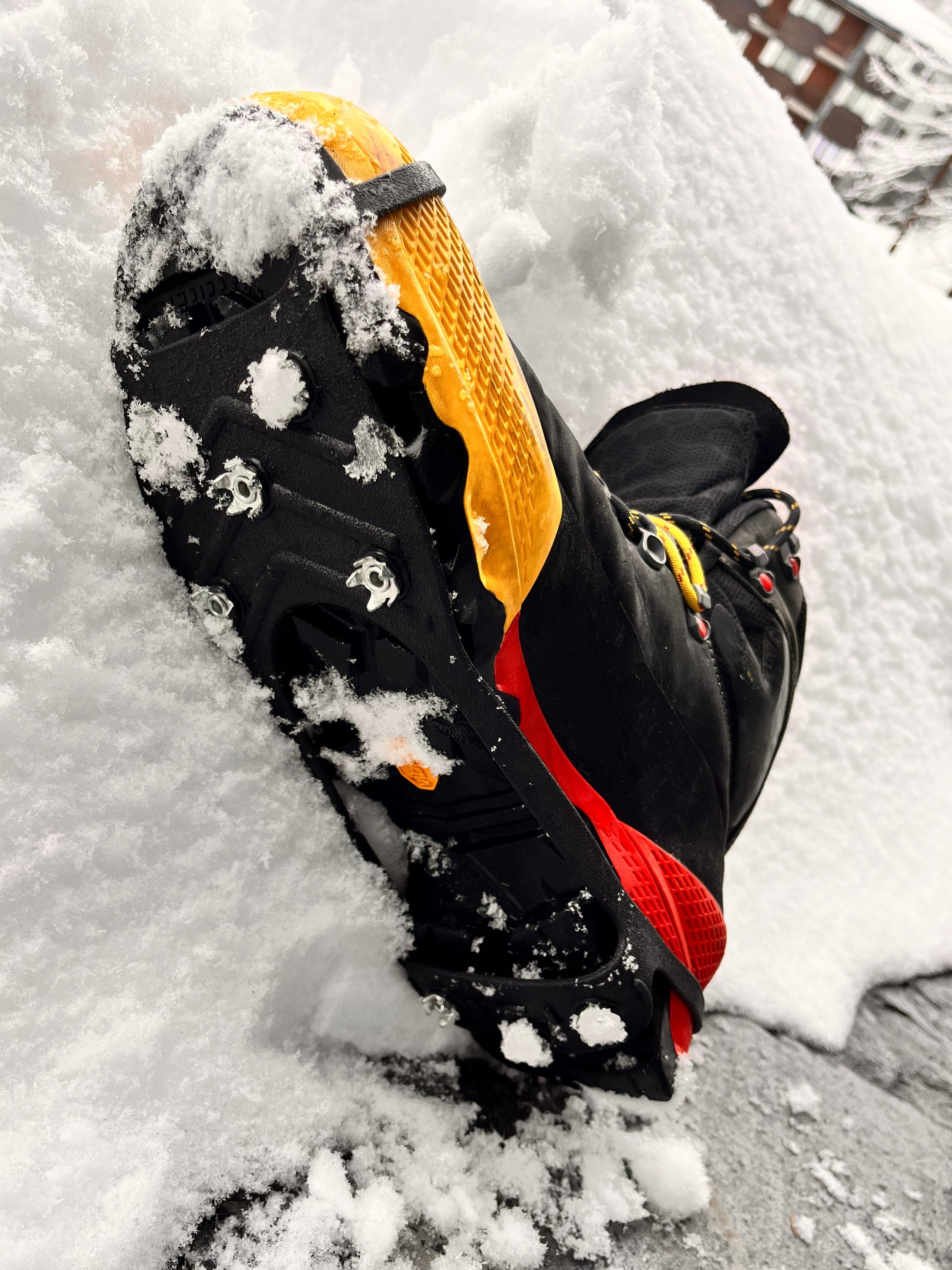 Hiking boots with The Adirondack Tool Co.'s microspikes on a snowy background