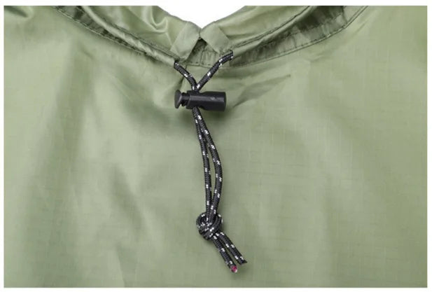 Close-up of a green 2-in-1 tarp and poncho from The Adirondack Tool Co. with a black cord and knot detail.