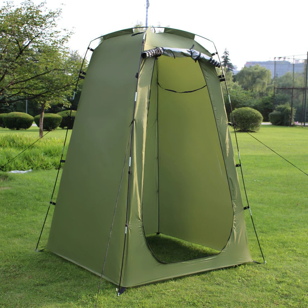 Green privacy tent with black poles and straps on grass - offered by the best outdoor gear company in New York, The Adirondack Tool Co.