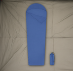 Blue sleeping bag with a matching carrying bag on a tent floor background - offered by the best camping gear store in New York, The Adirondack Tool Co.