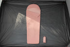 Pink sleeping bag with a matching carrying bag on a tent floor background - offered by the best camping gear store in New York, The Adirondack Tool Co.