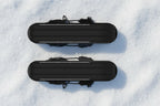 the bottom of black snow skates, pictured on a snowy background - offered by the best hiking gear store in New York, The Adirondack Tool Company