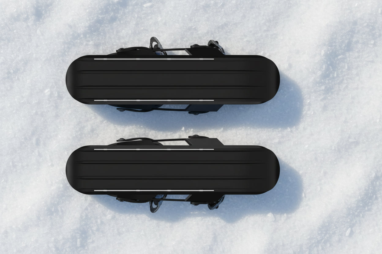 the bottom of black snow skates, pictured on a snowy background - offered by the best hiking gear store in New York, The Adirondack Tool Company