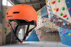 Orange sports helmet on a rock-climbing background - offered by the best outdoor sports gear store in Massachusetts, The Adirondack Tool Co.