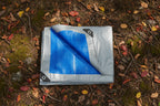 Blue and gray tarp with grommets on a white background - offered by the best hiking and camping gear provider in the Northeast, The Adirondack Tool Co.