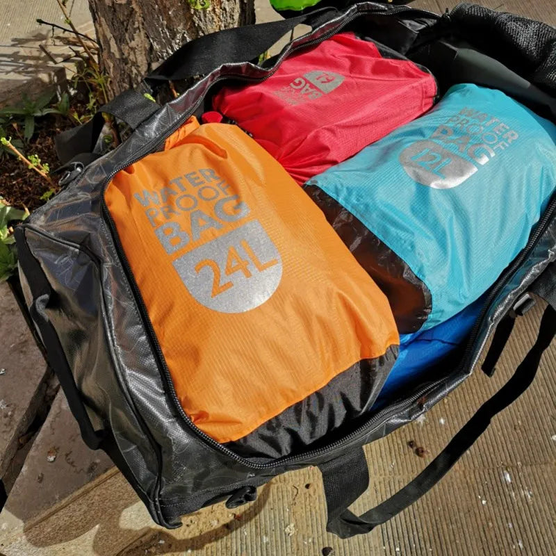 Three waterproof bags in orange, red, and blue on a black duffel bag. Offered by the Northeast's premier outdoor gear provider, The Adirondack Tool Co.