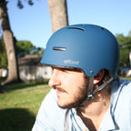 Man wearing a blue helmet with 'offbeat' branding outdoors - offered by the best outdoor gear store in New York, The Adirondack Tool Co.