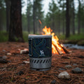 Portable stove with topographic design and brand logo on a forest background - offered by the best camping gear store in Pennsylvania, The Adirondack Tool Co.